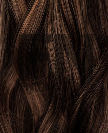 Luxury human remy hair extensions with smooth, shiny brown strands for natural volume and length.