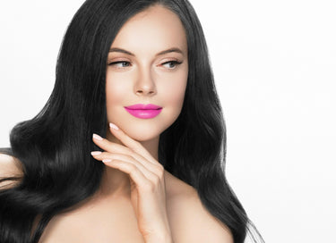 Luxurious black wavy hair extensions with vibrant pink lipstick